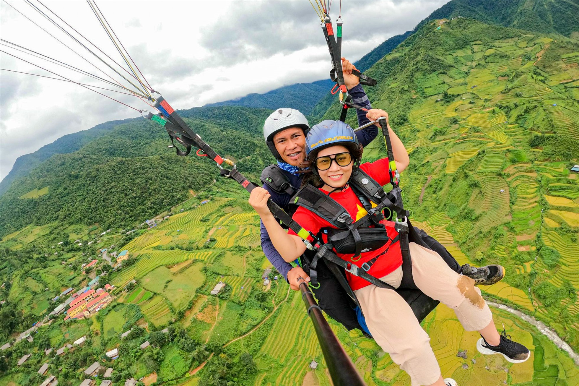 Du khách thích thú trải nghiệm dù lượn ngắm nhìn ruộng bậc thang từ trên cao tại Khau Phạ 
