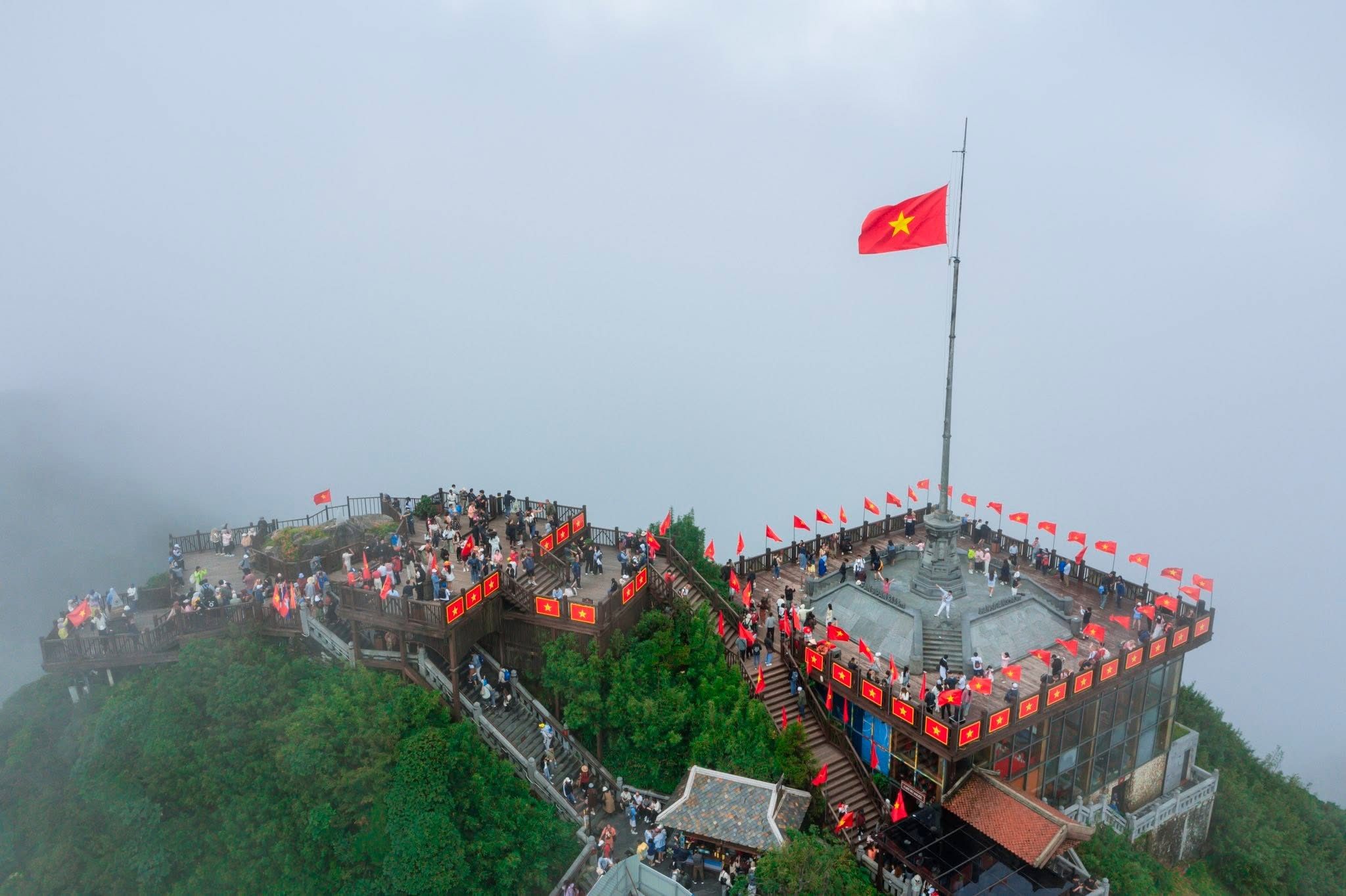 Lá cờ đỏ sao vàng tung bay giữa mây trời Fansipan trong dịp Quốc khánh. 
