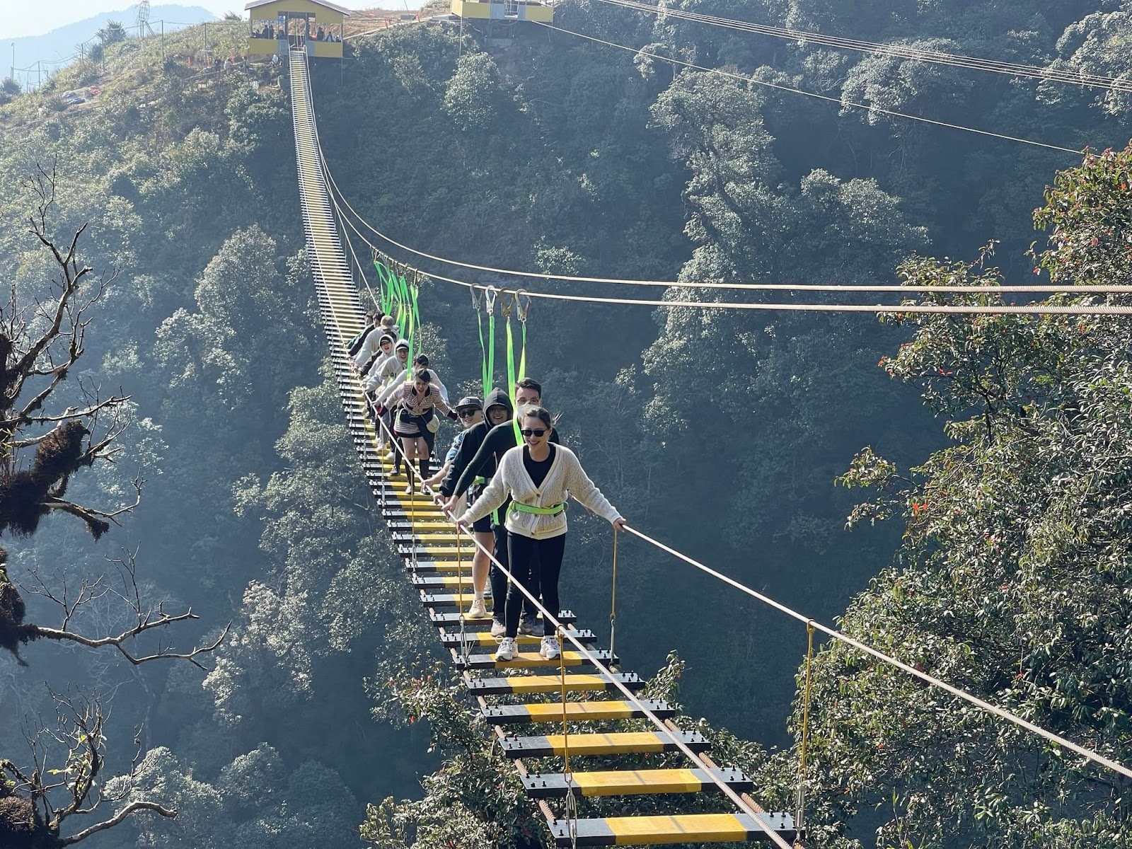 Du khách trải nghiệm trò chơi cảm giác mạnh tại cầu kính Rồng Mây. 