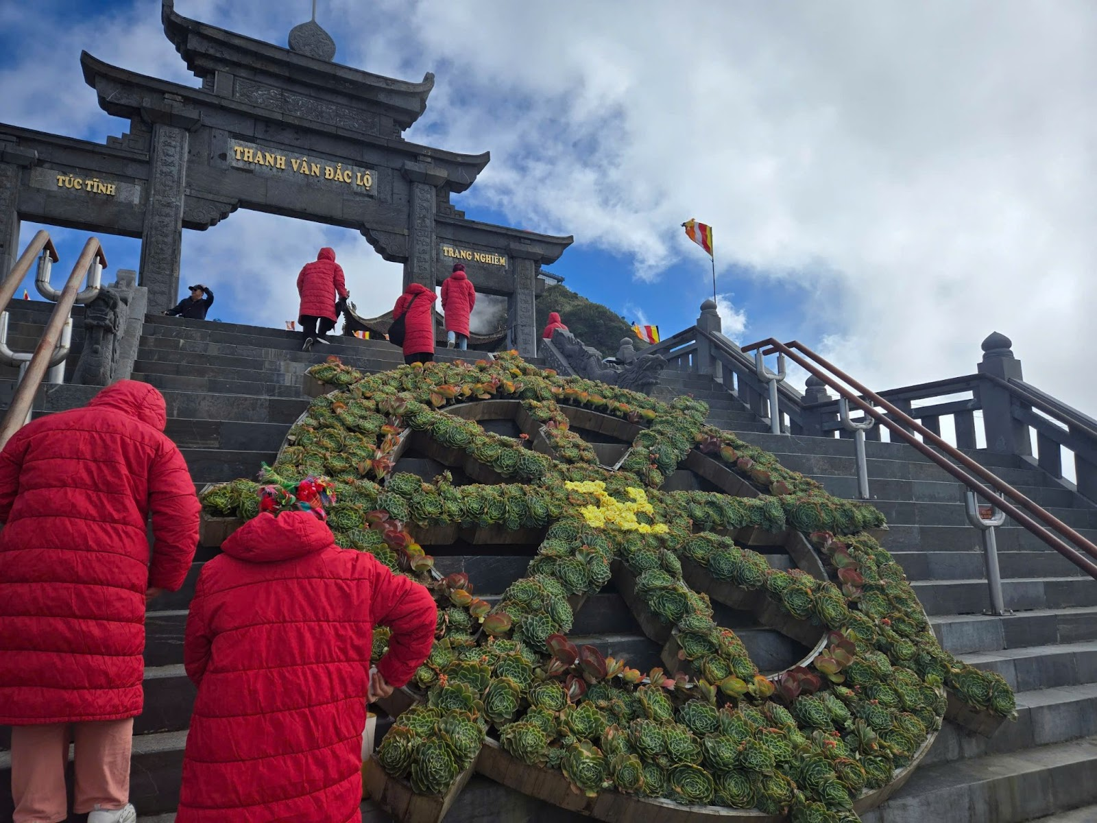 Tại cổng Thanh Vân Đắc Lộ, hình ảnh bánh xe pháp luân được ghép từ hàng trăm cây sen đá xanh Sa Pa.