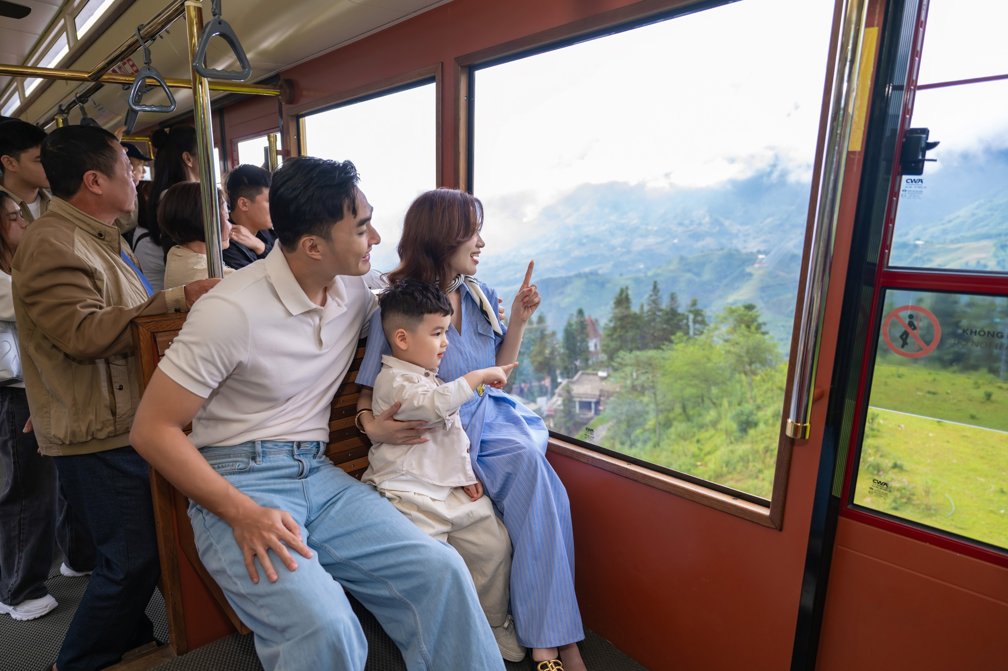 Du khách cùng gia đình ngắm nhìn thung lũng Mường Hoa từ cabin cáp treo Fansipan.