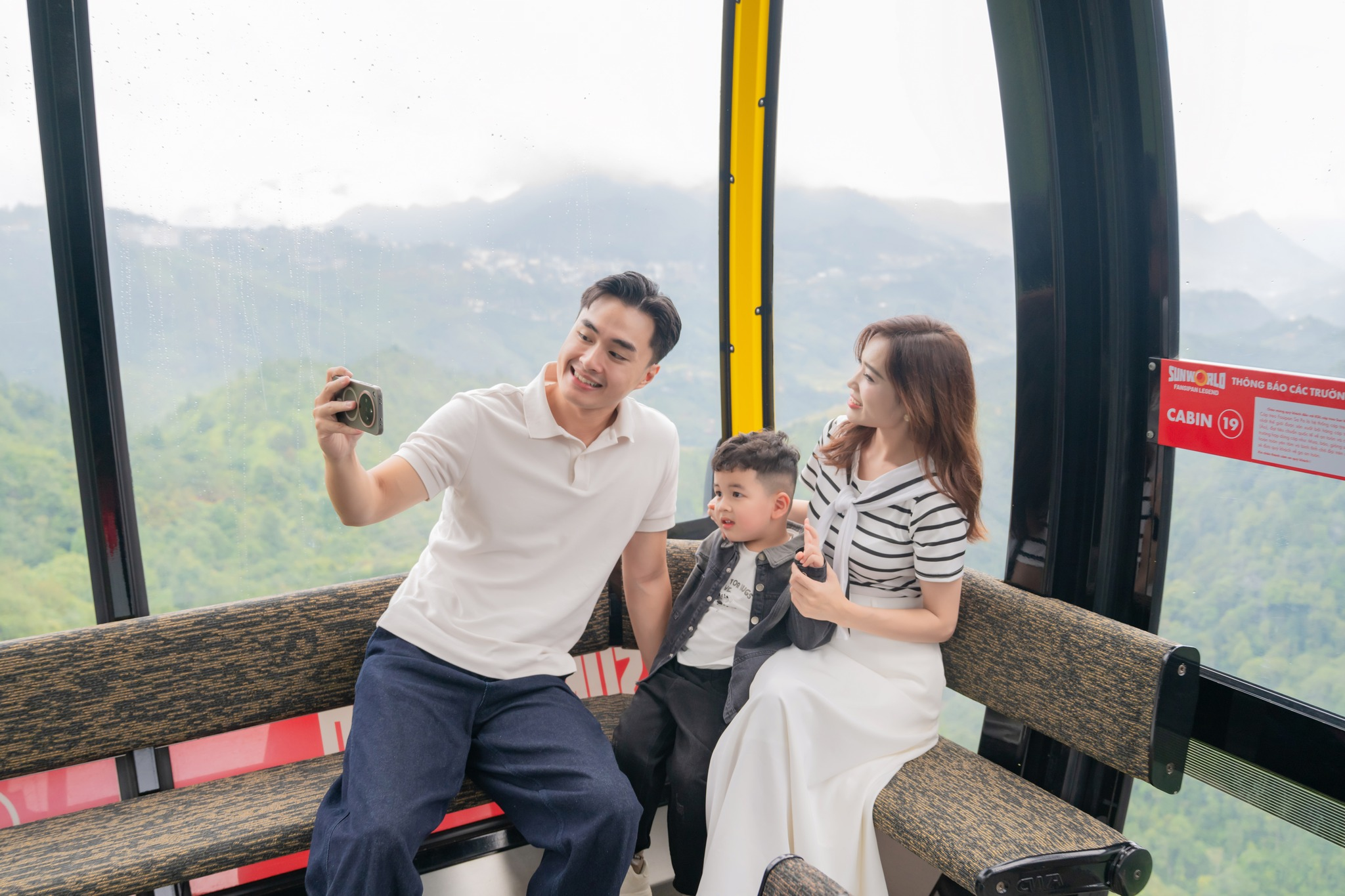 Du khách cùng gia đình ngắm nhìn thung lũng Mường Hoa từ cabin cáp treo Fansipan.
